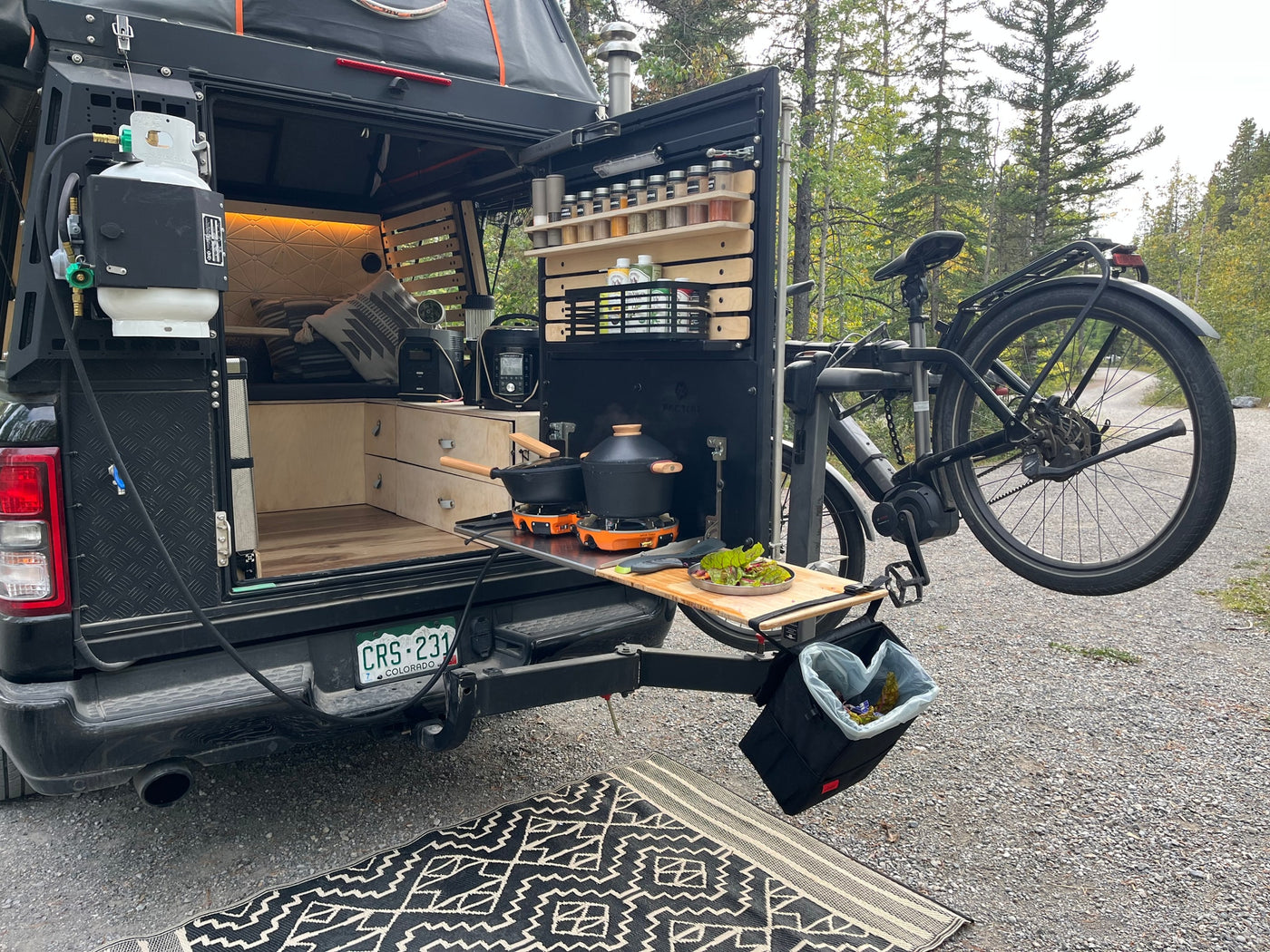 RV rental: Rear truck bed camper with full outdoor kitchen, propane stove, spices, and e-bike mount for remote cooking. — photo 13