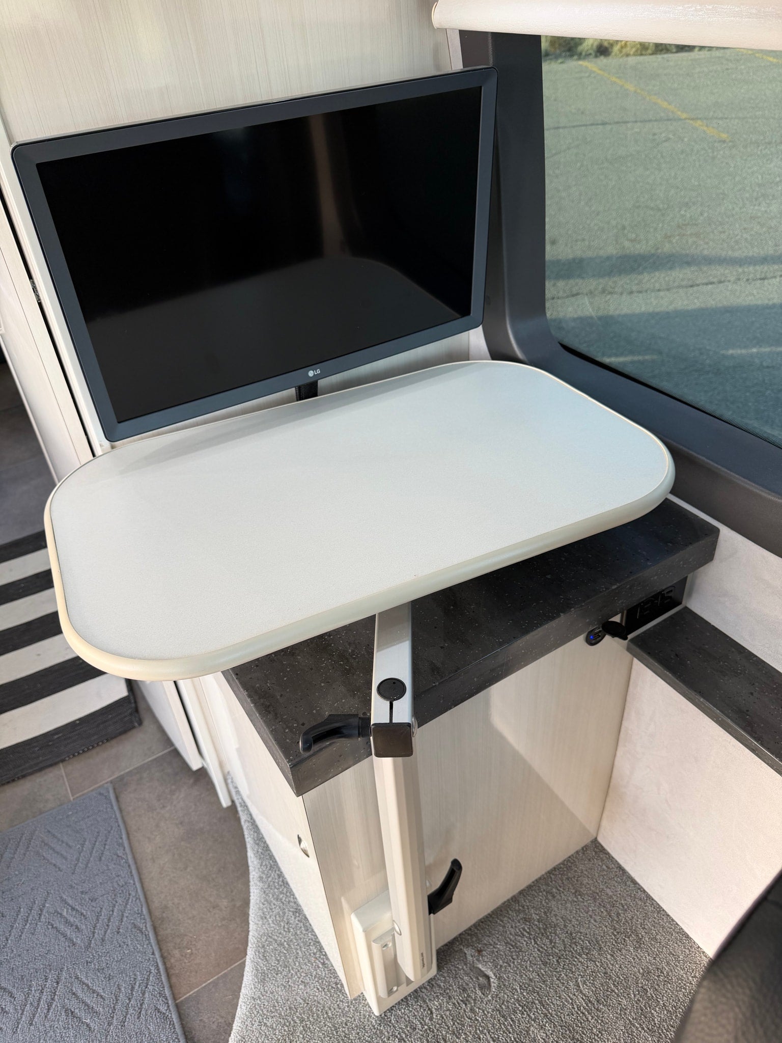 RV rental interior features an LG TV above a practical swing-out table, with USB charging integrated into the counter.