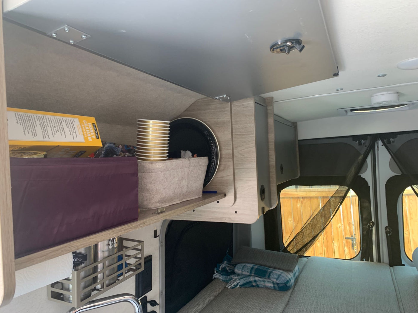 and a compact kitchen.|Compact RV rental wet bath: Features a toilet — photo 7