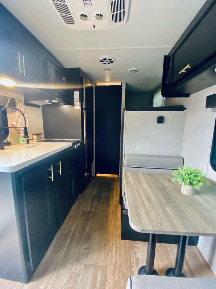 and an open door viewing autumn trees.|RV rental shower featuring a compact design