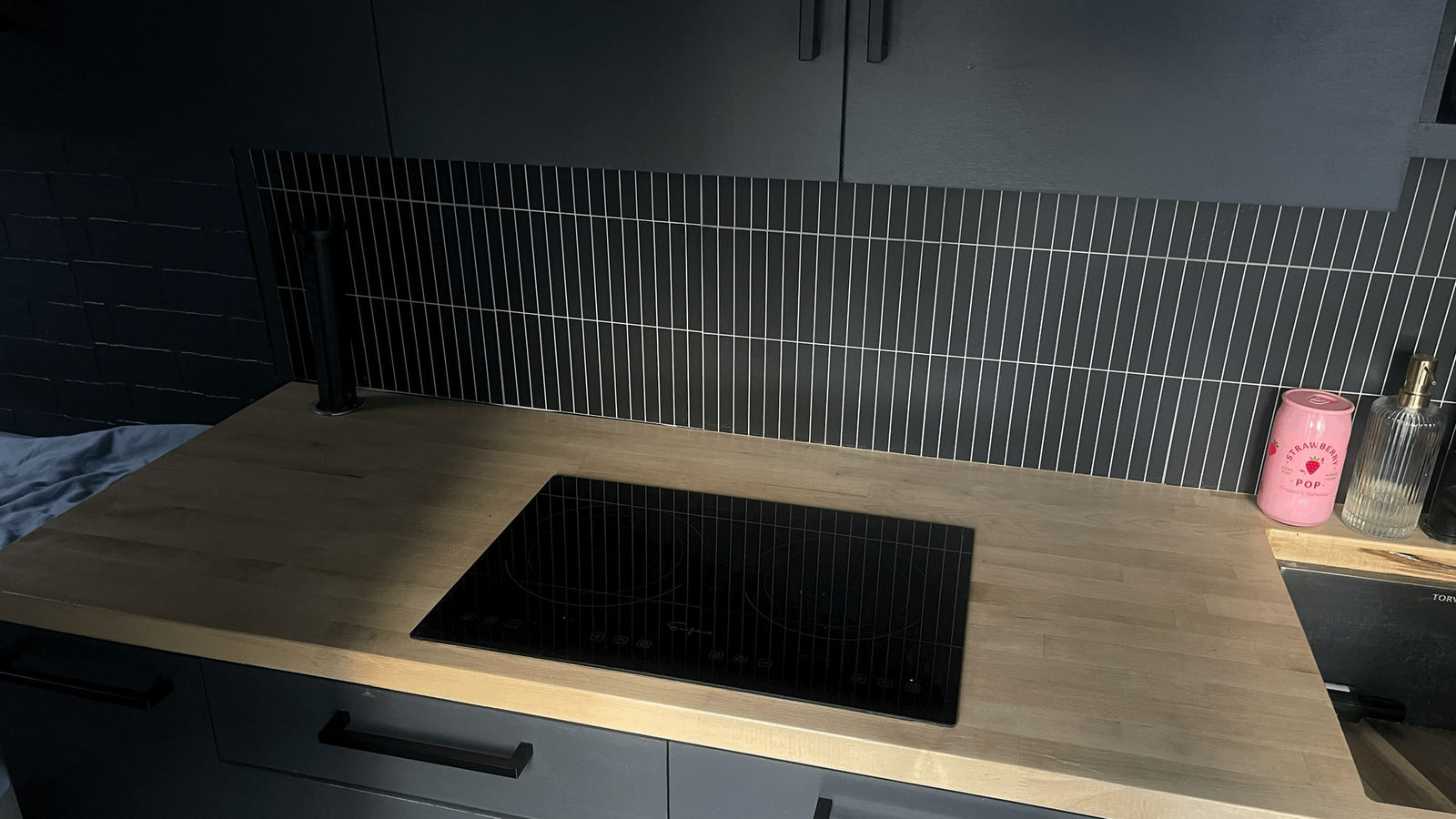 dark grey kitchen in an RV rental with light wood counters