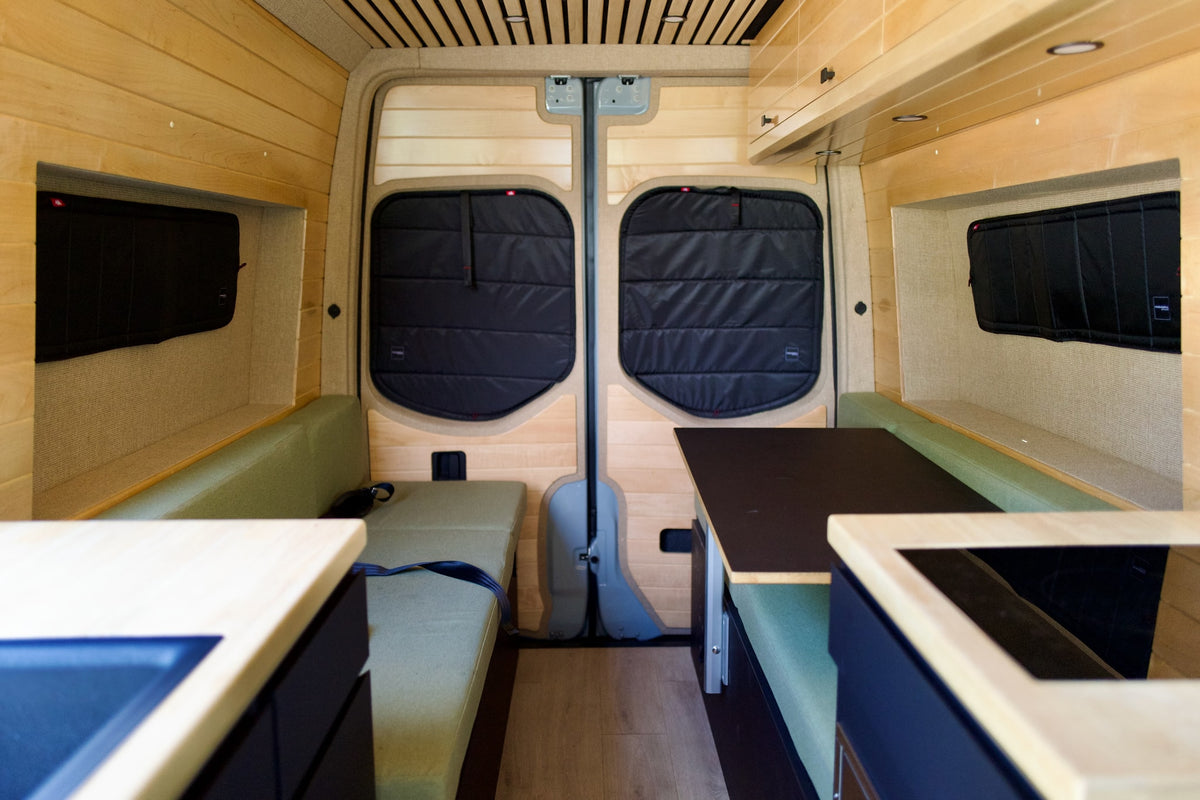 Cozy rv rental interior: wood-paneled camper van with kitchenette, dining, and sleeping areas visible. — photo 13