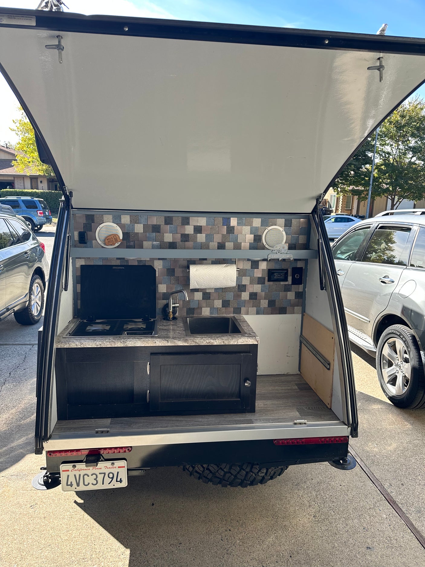 This RV rental's smart outdoor kitchen, with a stove and sink, is perfect for camping and travel adventures.