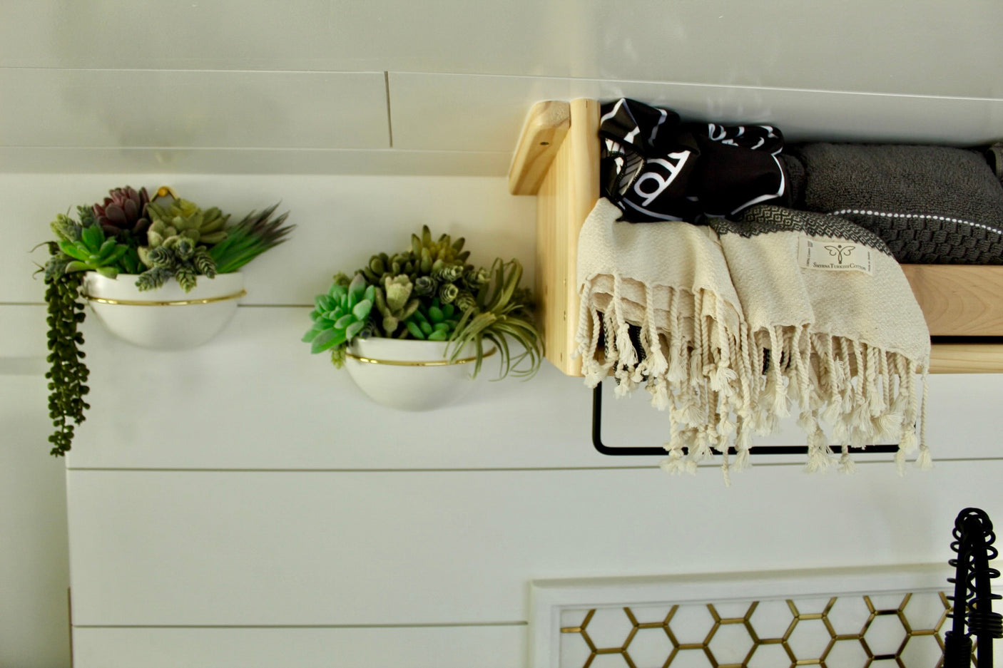 RV rental decor: Faux succulents in wall planters & organized storage shelf with Smyrna Turkish cotton towels.
