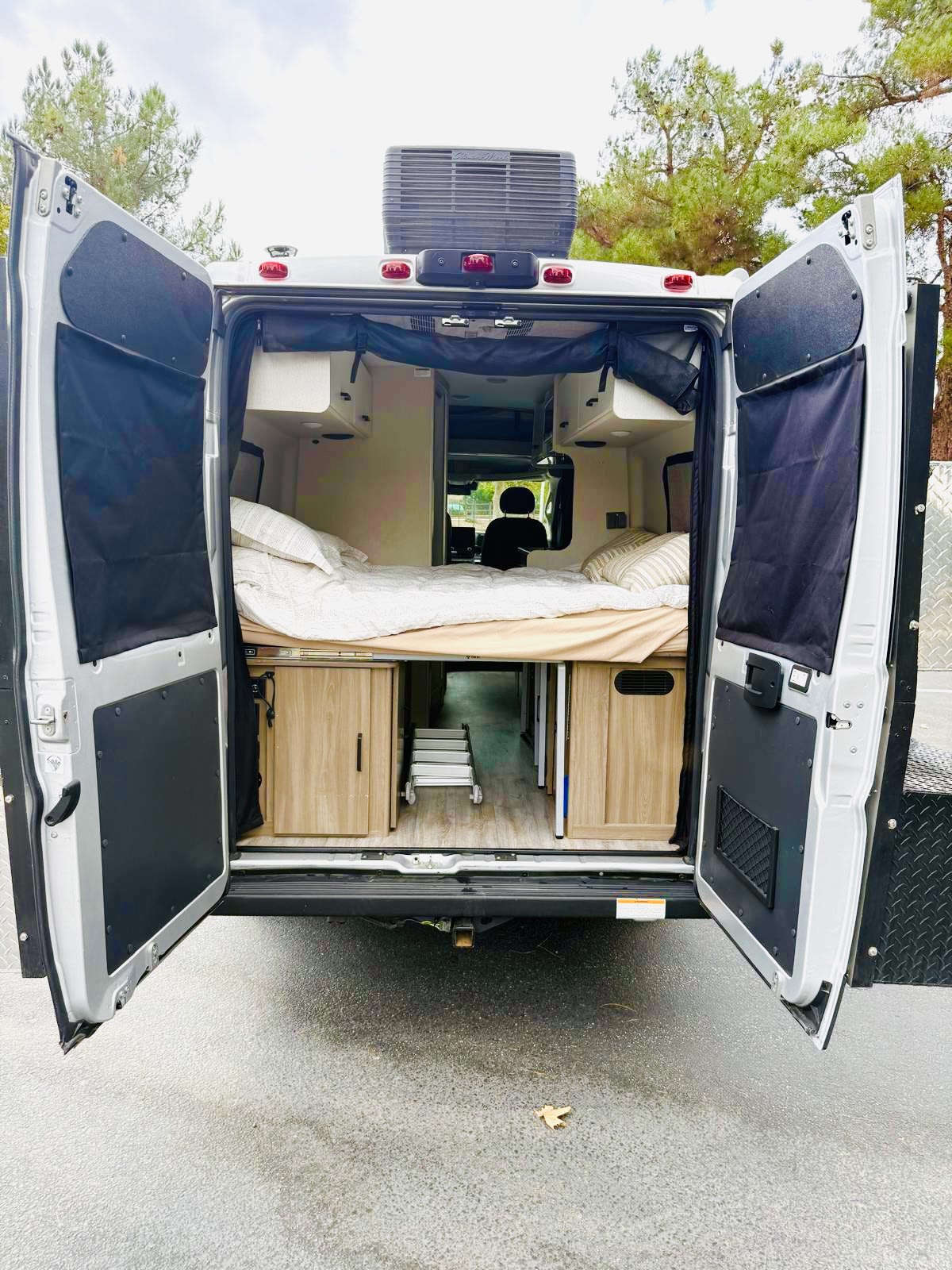 and a ladder to an upper bunk bed.|Inside an RV rental: a compact dinette with comfortable seating — photo 7