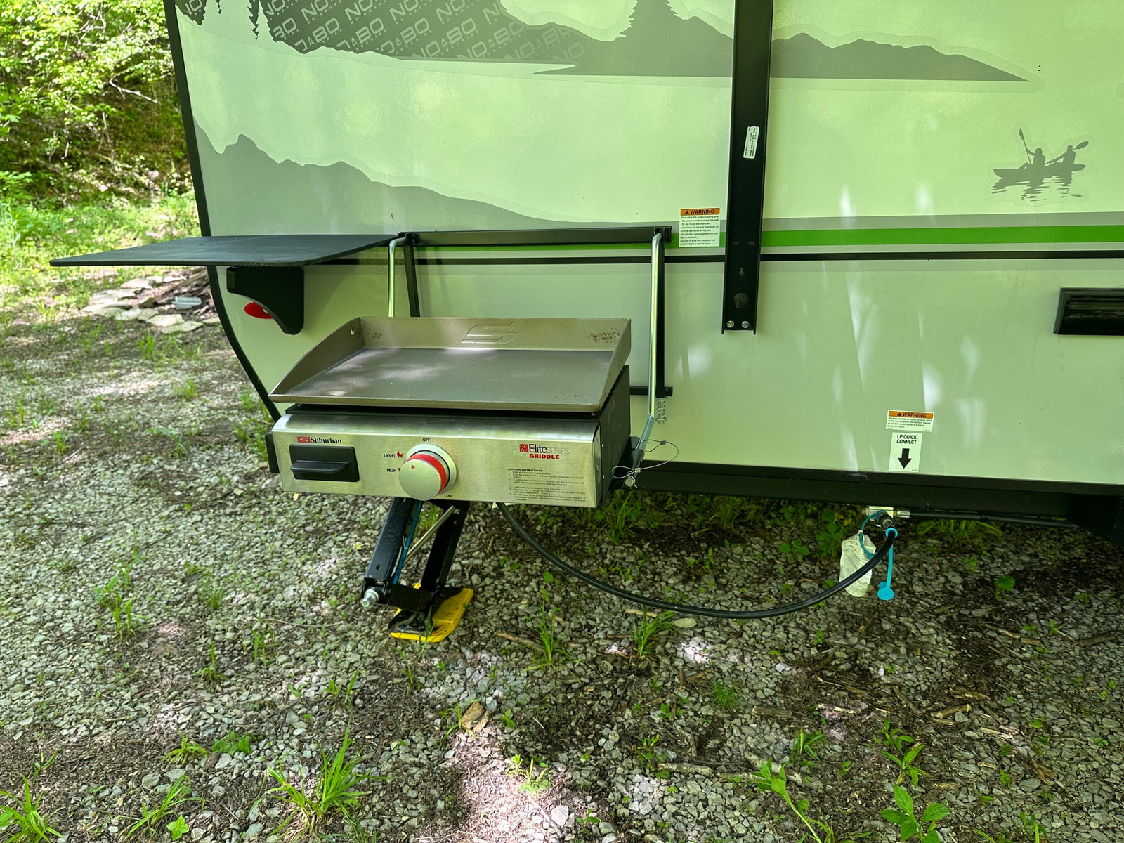 RV rental outdoor cooking setup: Suburban Elite griddle attached to an RV, connected to LP quick connect.