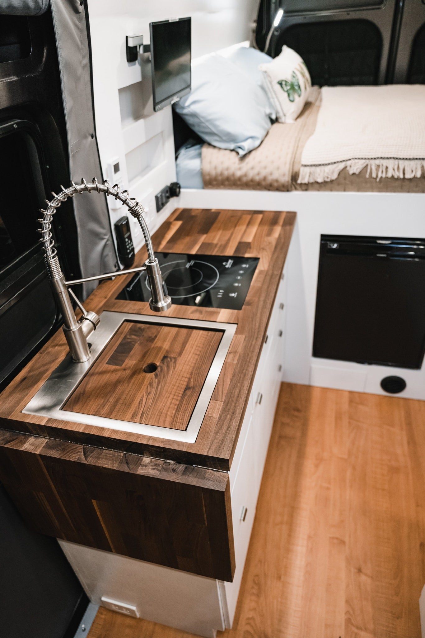 & power outlets in this modern camper van conversion.|This rv rental's modern interior features a sleek kitchen with induction cooktop