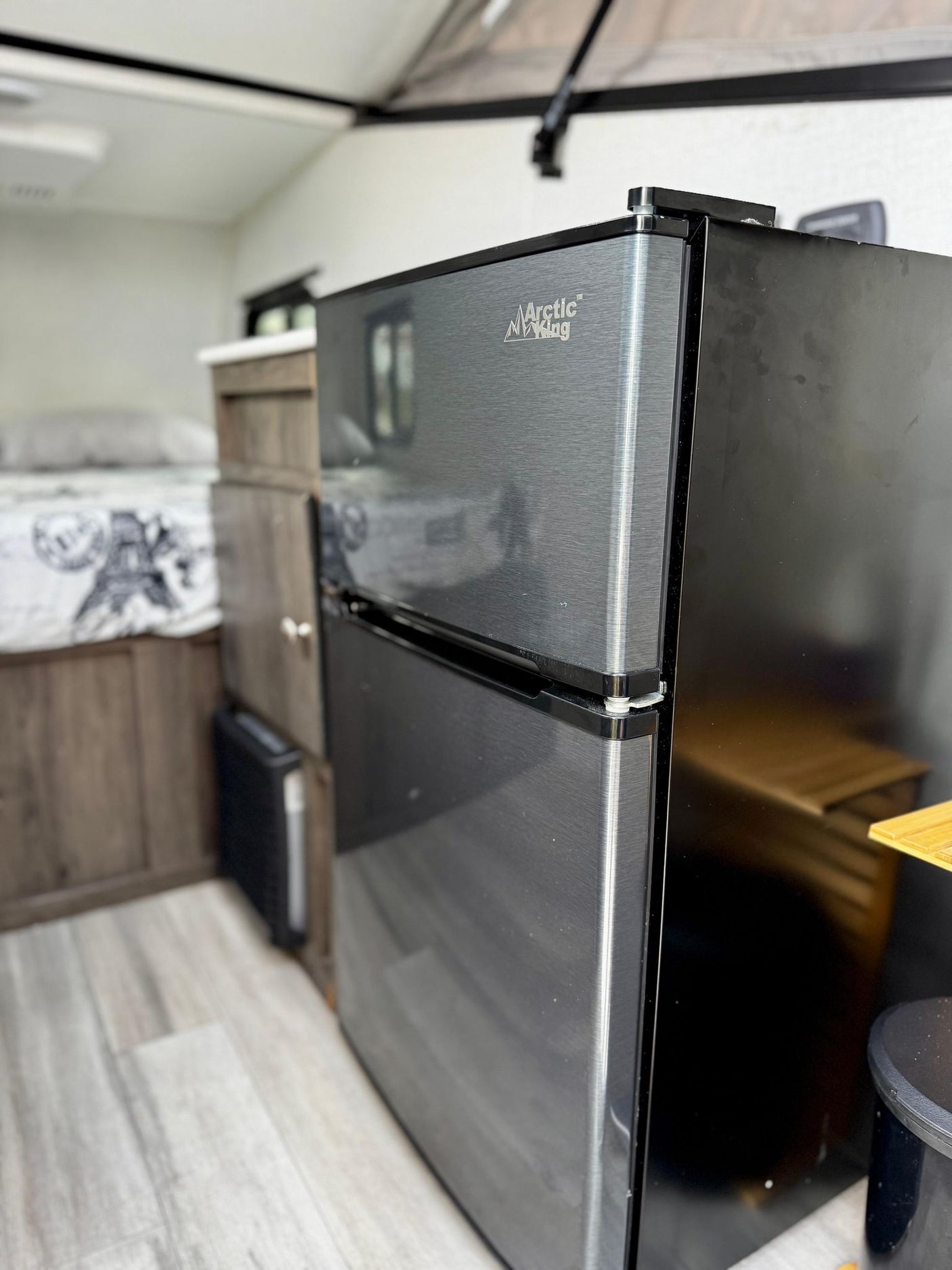 and rugged spare tire mounted on the trailer's front tongue.|Open RV rental storage: wooden cutting board