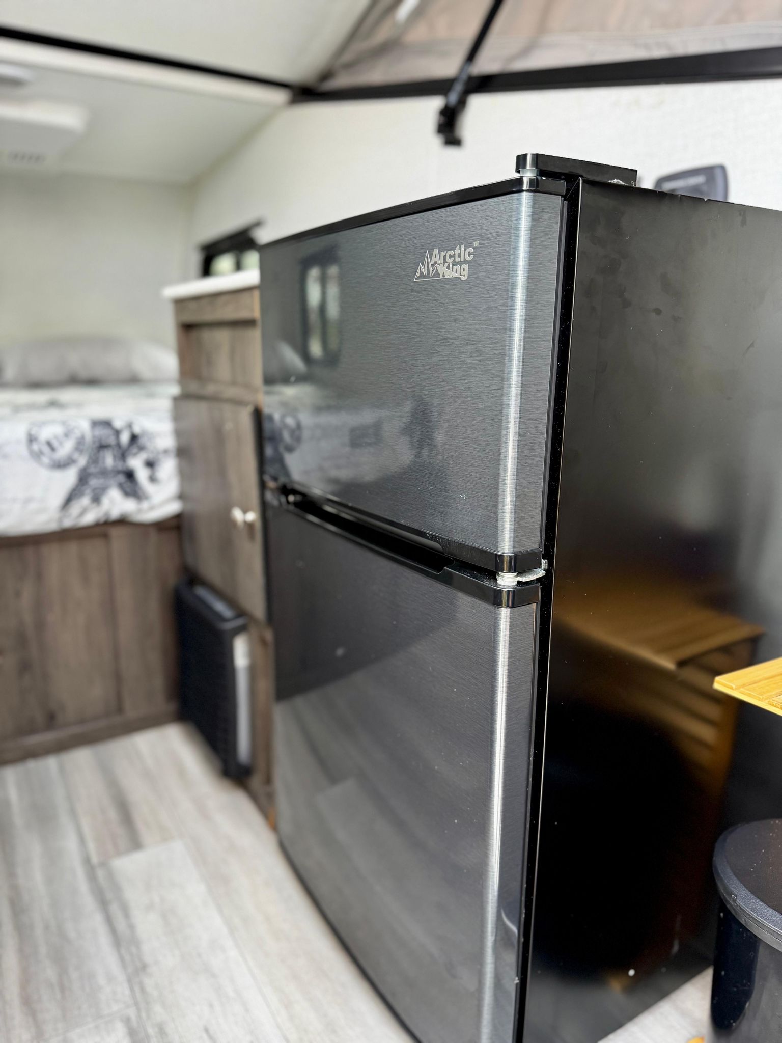 and rugged spare tire mounted on the trailer's front tongue.|Open RV rental storage: wooden cutting board
