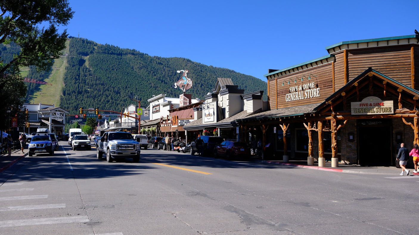 A bustling main street with shops like Five & Dime, backed by ski slopes, ideal for a mountain rv rental trip.