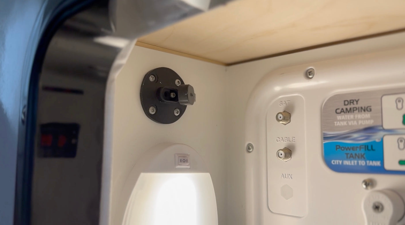 An RV rental's utility bay features SAT/CABLE/AUX connections, water system details for dry camping & tank filling, plus a light.