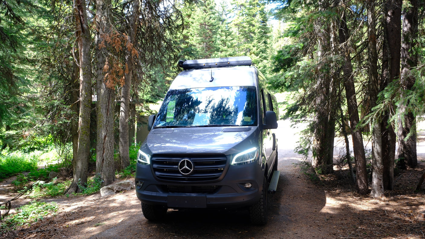 and steaming vents. An RV rental is perfect for this natural wonder.|Grey Mercedes Sprinter rv rental camper van by a scenic river
