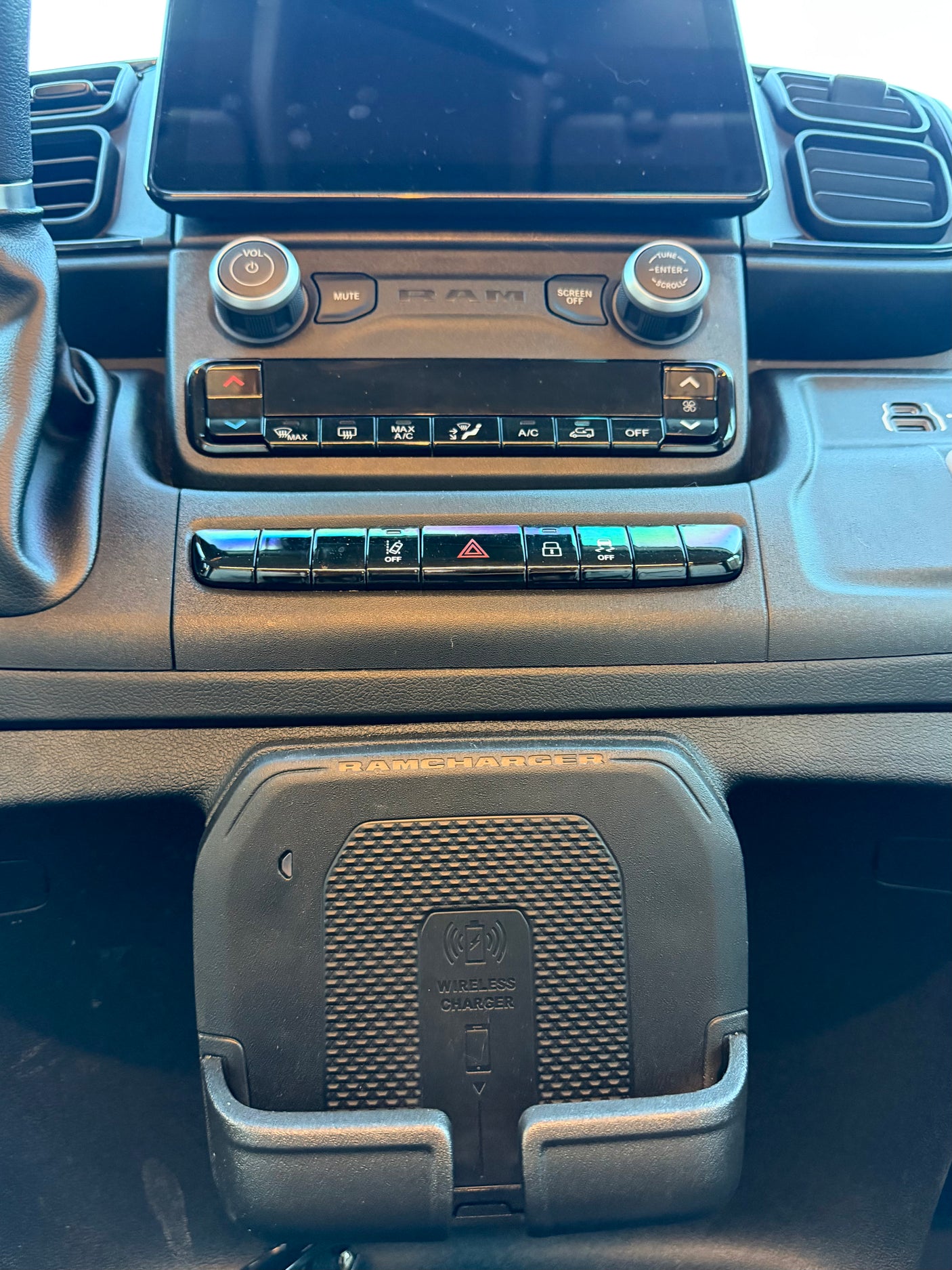 RV rental dash showing a modern infotainment system, climate controls, and a "RAMCHARGER" wireless phone charger.