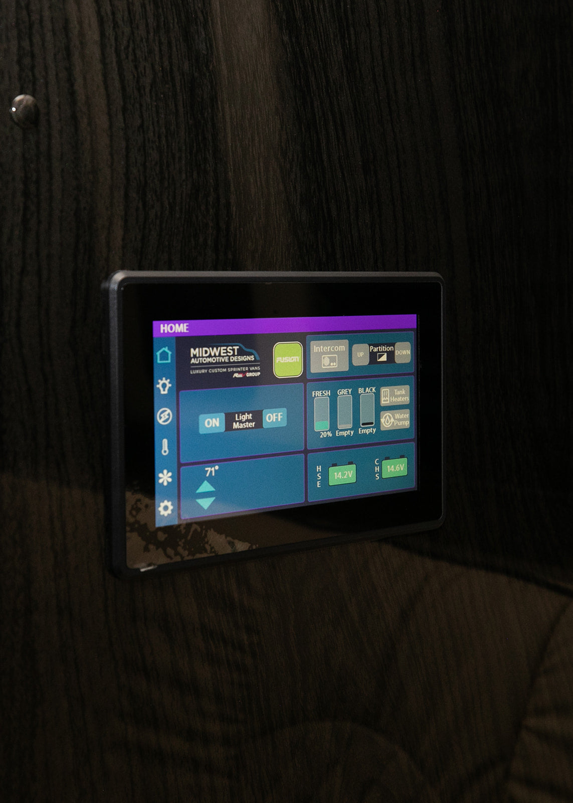 An RV rental's smart digital control panel displays tank levels (fresh 20%), lighting, intercom, and battery voltage.