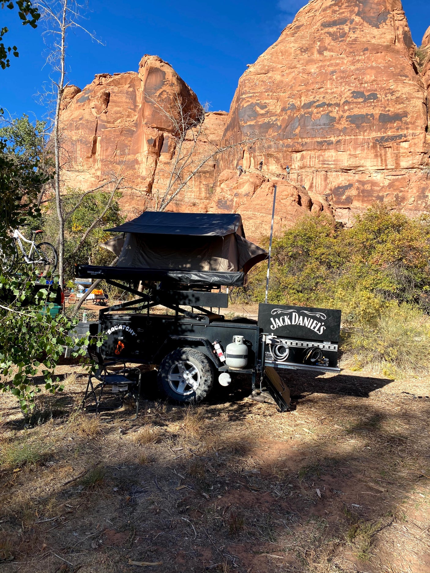 Adventure-ready trailer with rooftop tent at a red rock campsite, ideal for an rv rental escape into nature.