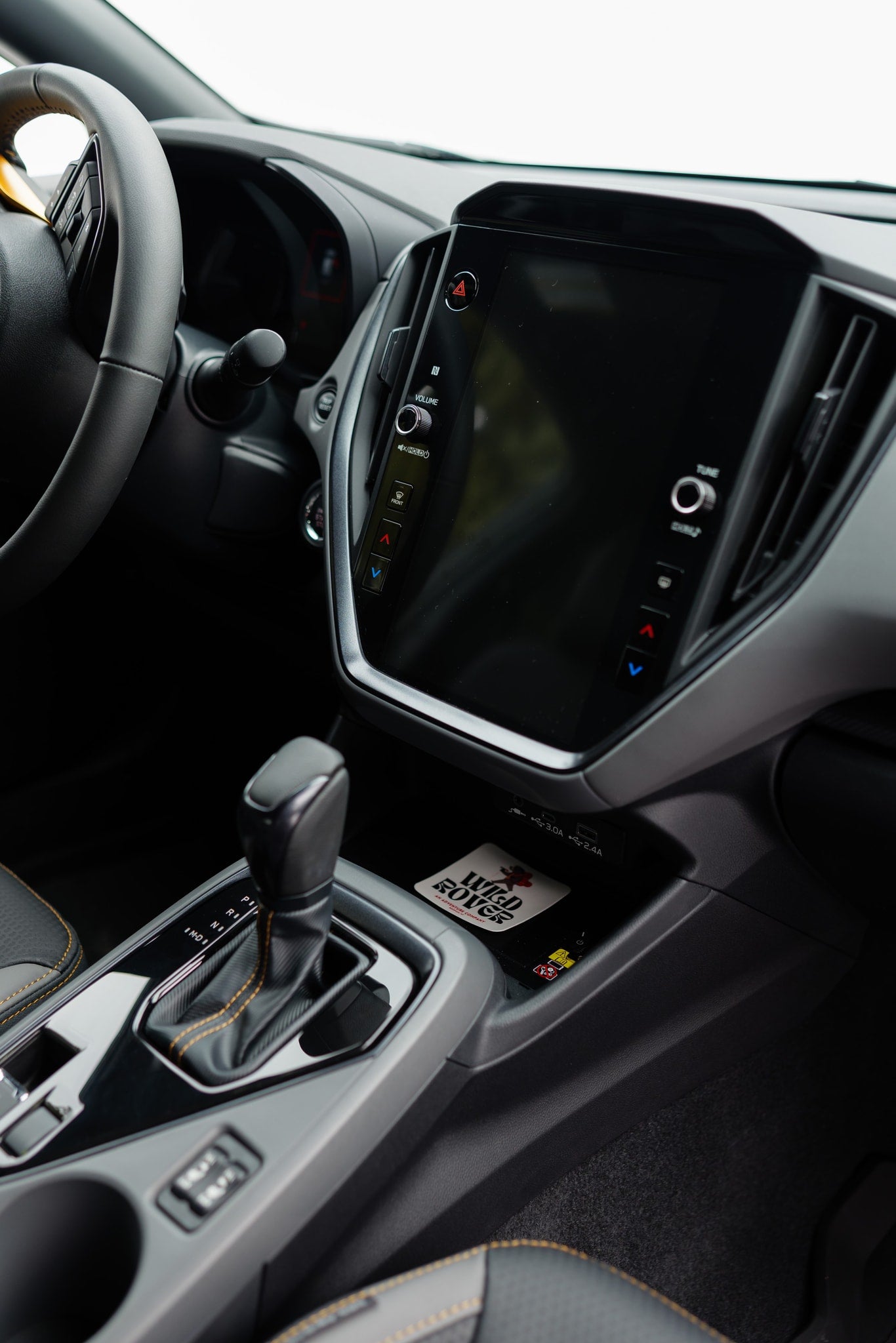 Modern car interior with steering wheel, large screen, and gear shifter. Ready for your next rv rental adventure.