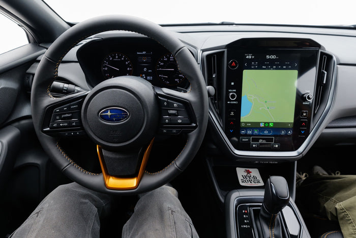 Inside a Subaru, showing the steering wheel, dash, and infotainment. Ideal vehicle for your next rv rental adventure!