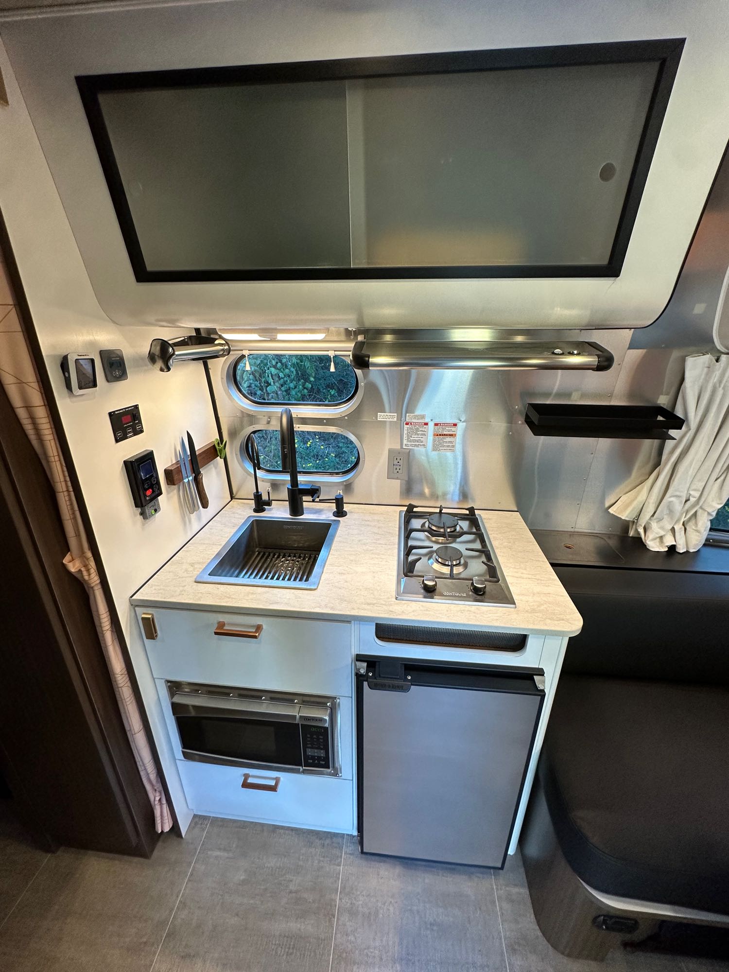 & overhead storage.|Explore this modern rv rental's compact kitchen