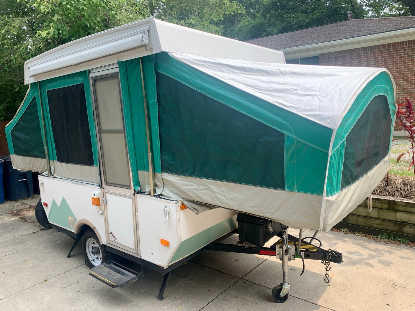 This white and green pop-up camper is fully set up