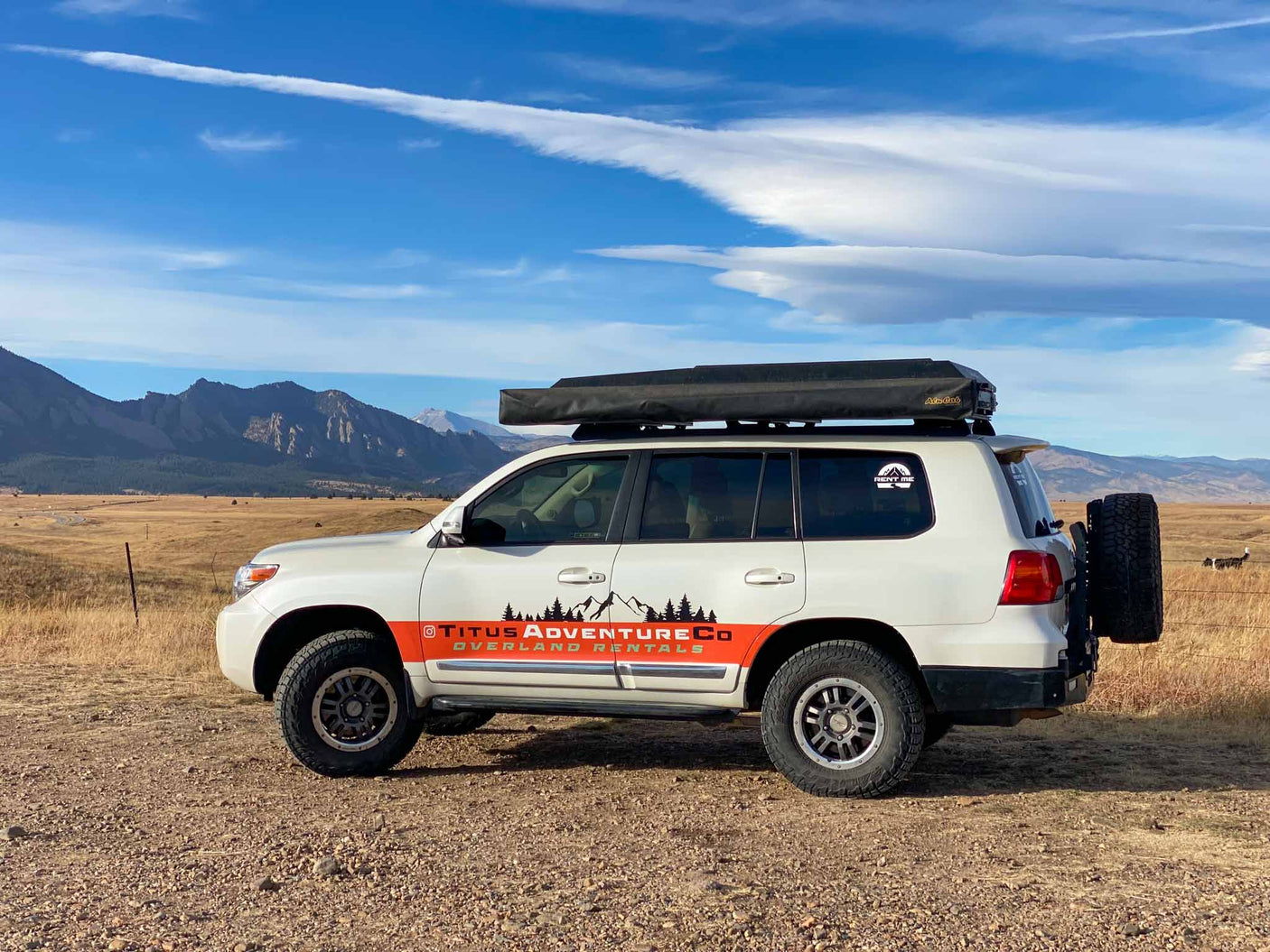 often preferred over an RV rental.|Titus Adventure Co. overland RV rental SUV parked amidst mountains