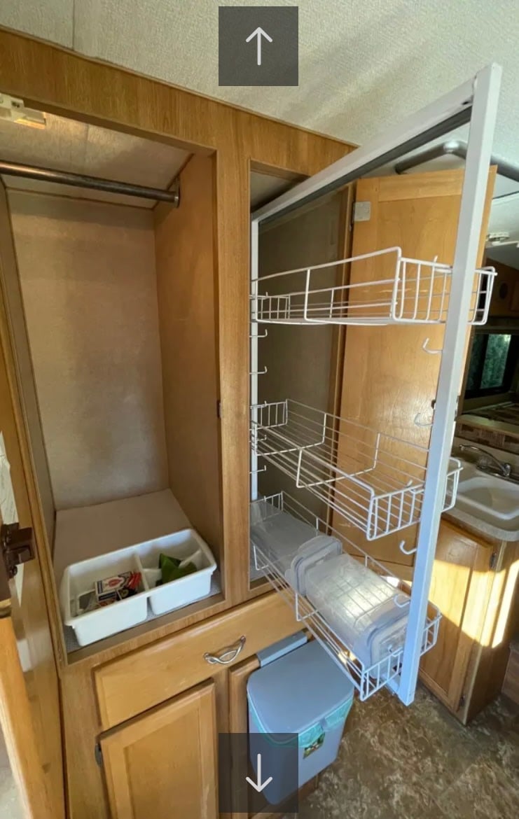 facing majestic mountains under a clear sky.|This RV rental features efficient storage with a well-organized closet — photo 6