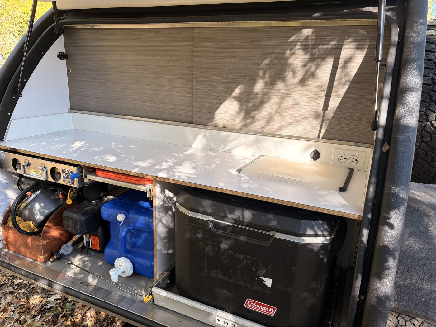 Side galley hatch open showing electrical system, battery and fridge slide — photo 8