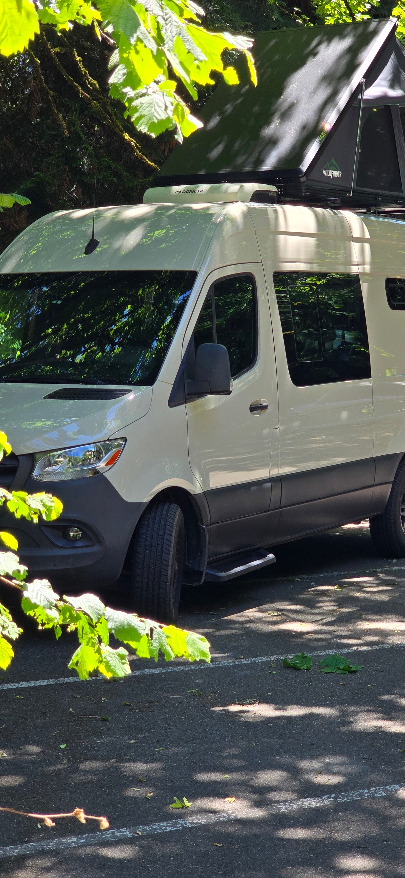 White camper van RV rental with Wildfinder rooftop tent & Dometic unit visible. Ready for adventure!