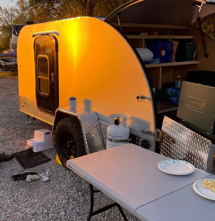 great for RV rental adventures in nature. Features a screen tent & essential gear.|Teardrop RV rental camper setup with open rear kitchen