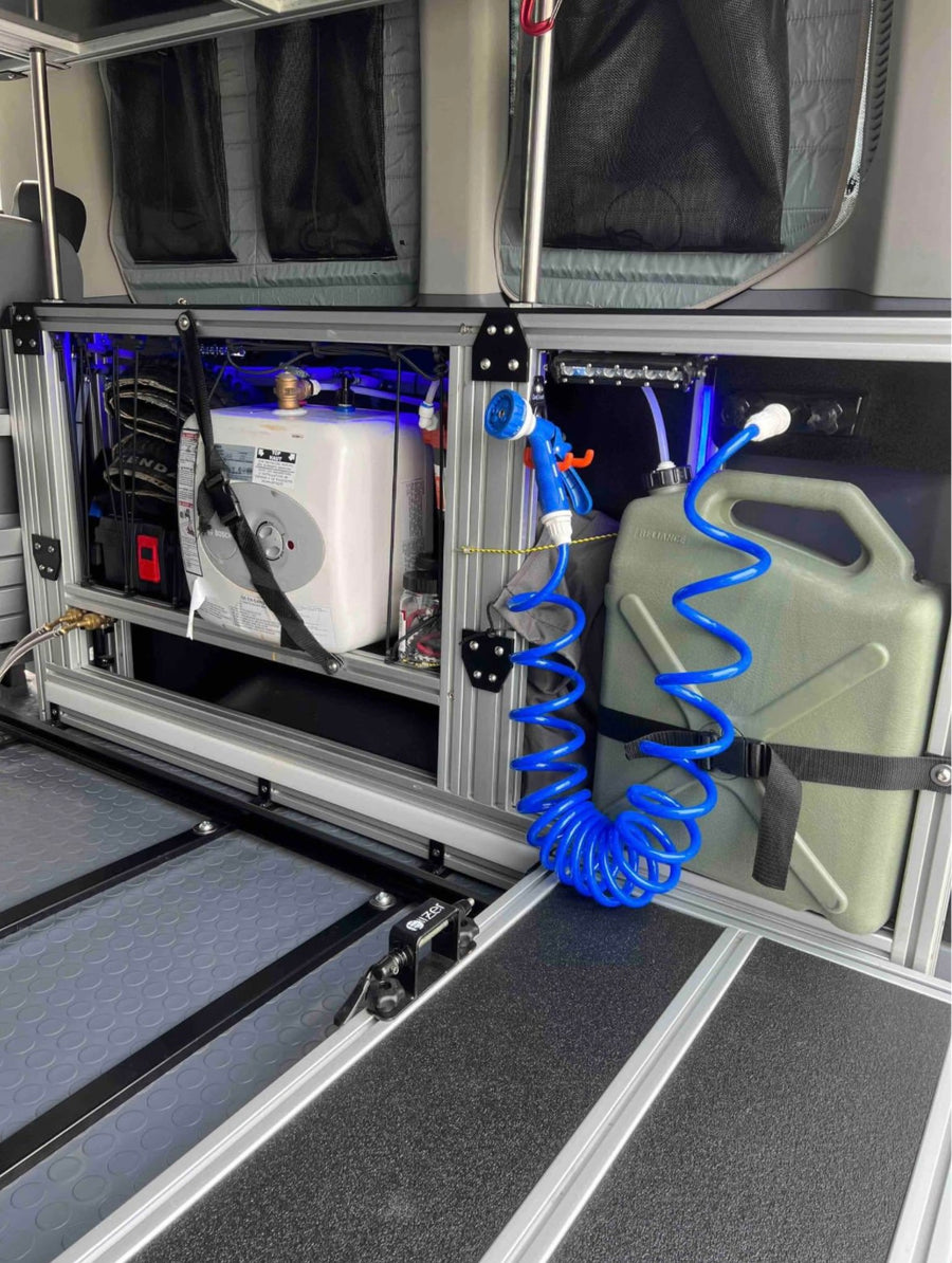 and water tank for efficient campervan adventures.|Adventure-ready RV rental: Van interior showing a pull-out bed