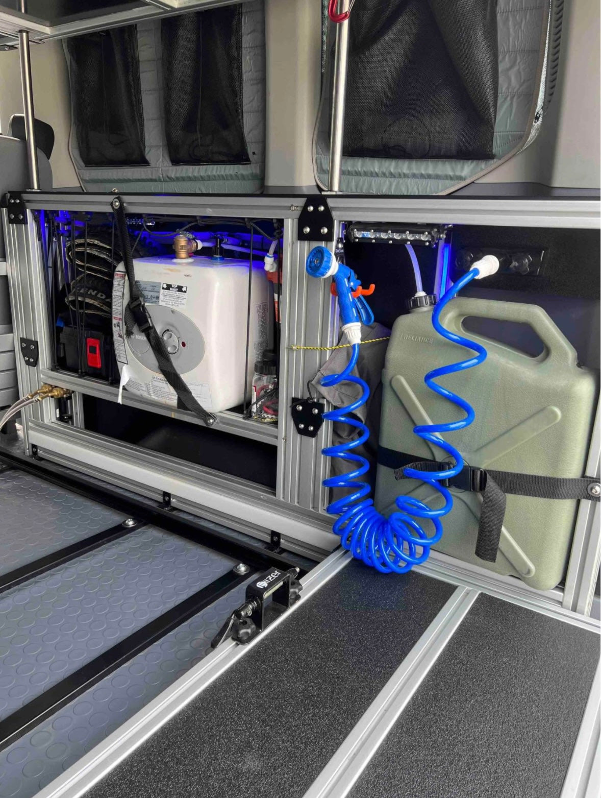 and water tank for efficient campervan adventures.|Adventure-ready RV rental: Van interior showing a pull-out bed