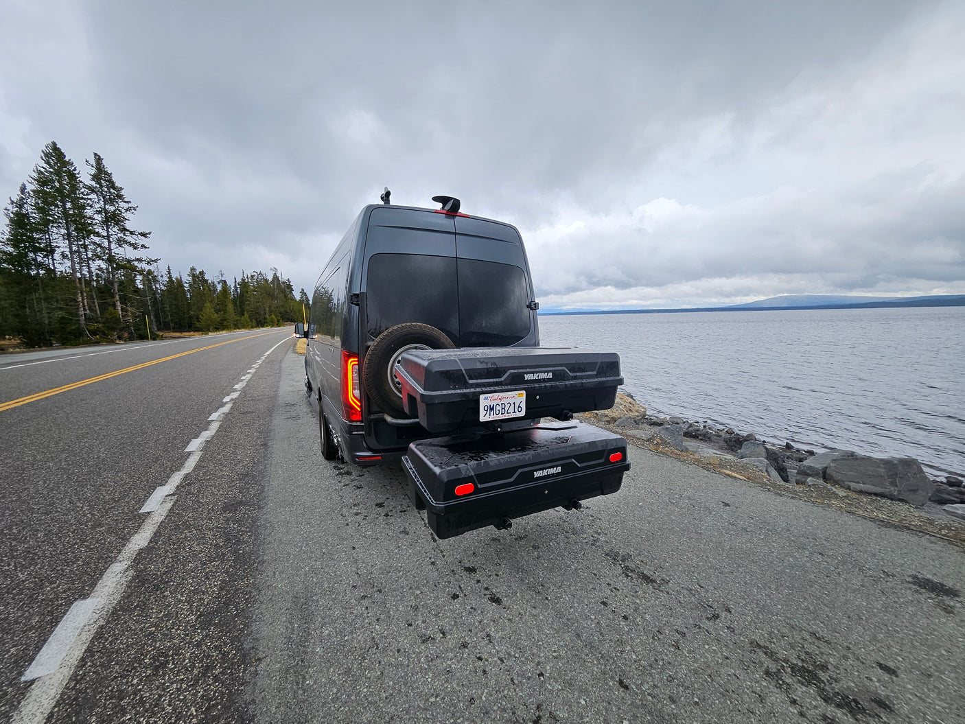 This Sprinter RV rental, equipped with storage, rests by a scenic lake, ready for adventure.