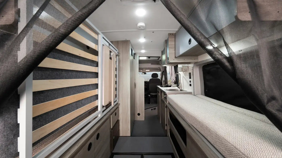 and scenic outdoor views through windows.|This RV rental offers a well-equipped compact kitchen with a stove