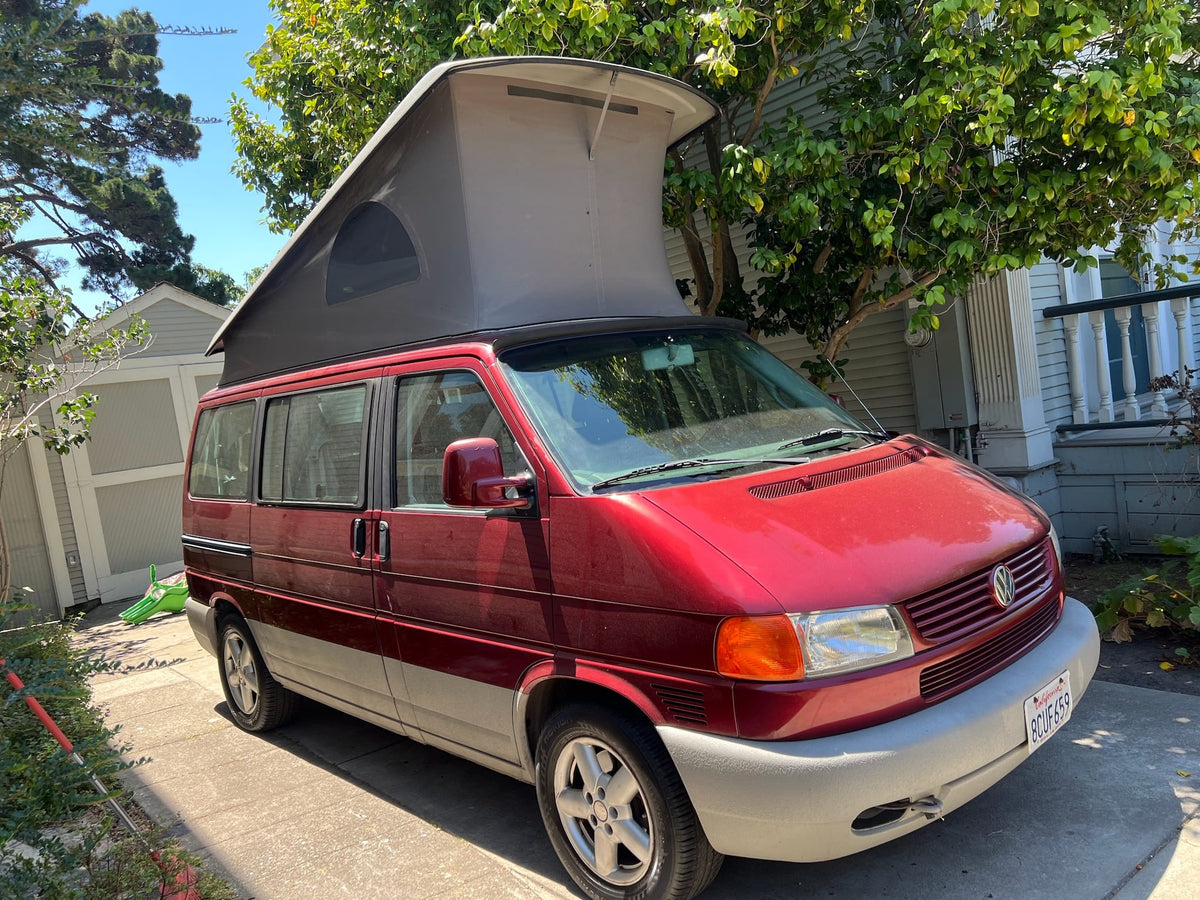ready for travel and adventure.|Iconic red VW pop-top camper van with its roof extended — photo 2
