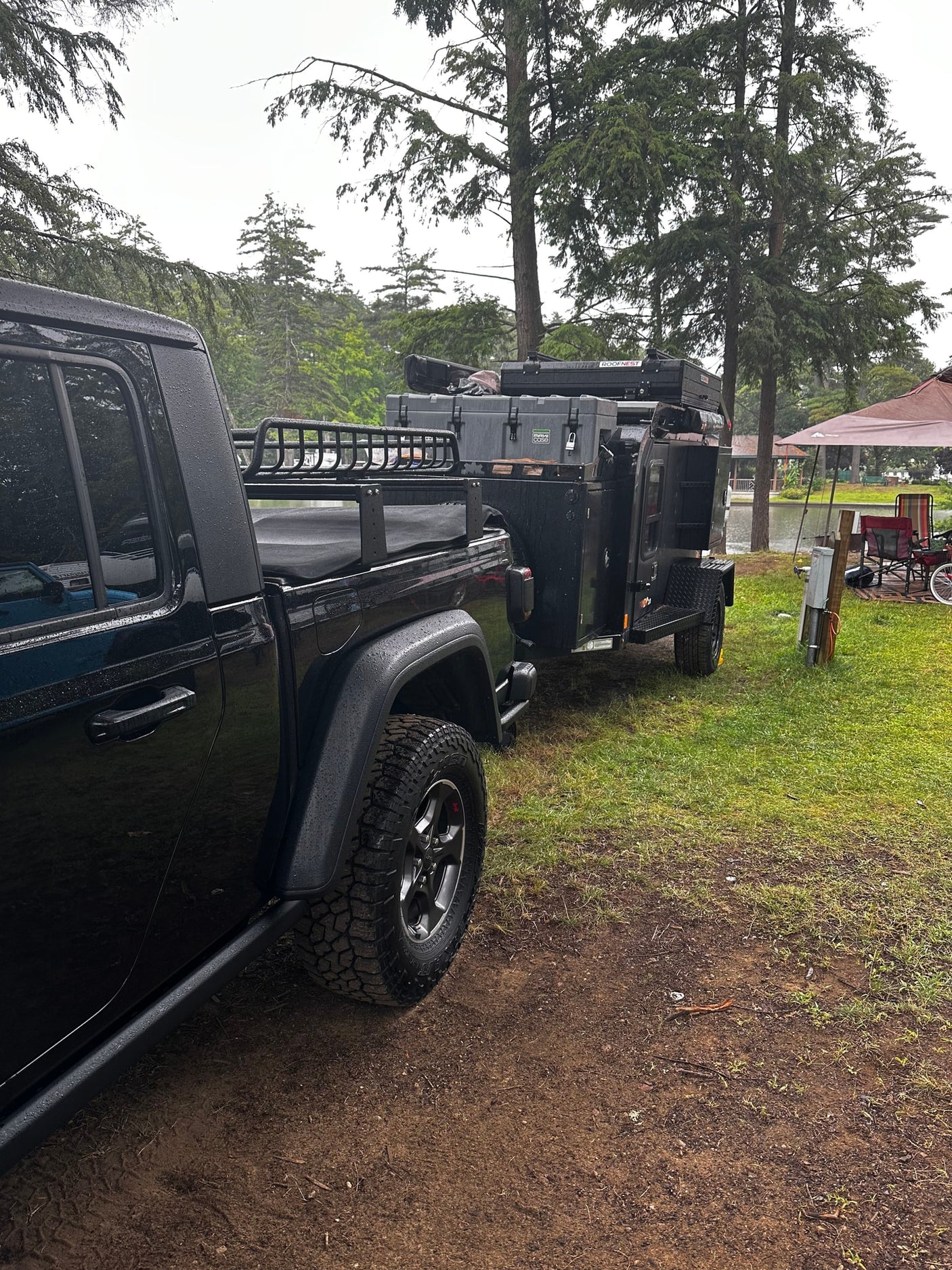 and overland trailer with rooftop tent.|A black Jeep Gladiator towing an overland camping trailer
