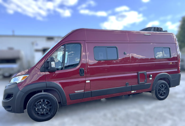 A vibrant red Winnebago Solis camper van, available for rv rental, parked outdoors. Perfect for your next adventure.
