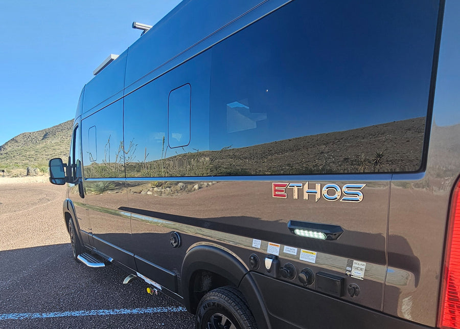 parked on gravel in a sunny desert landscape. Perfect for outdoor adventure.|Sleek grey Ethos campervan