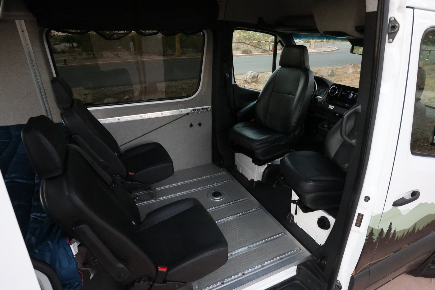 View inside a spacious RV rental, featuring adaptable black seating on a versatile modular track floor system. — photo 14