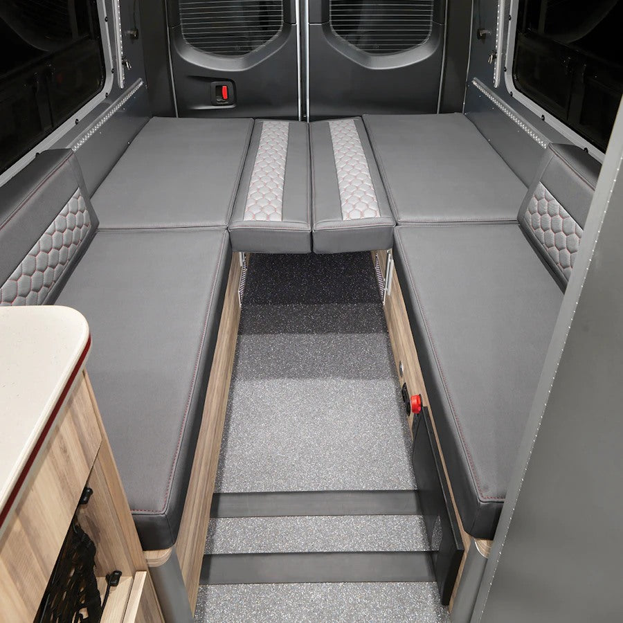 RV rental: Versatile gray U-shaped seating transforms into a comfortable bed, ready for your adventures. Ideal for camper van interiors.