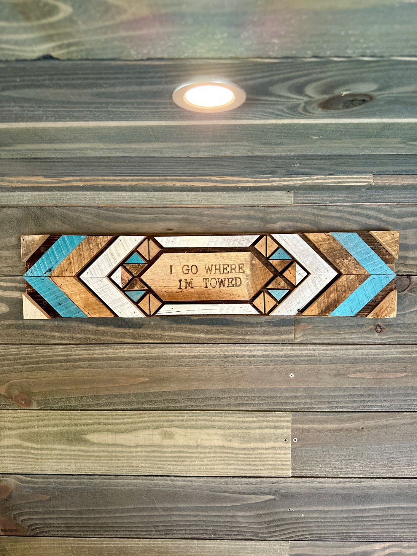 and lighted overhead cabinets.|Rustic RV rental interior featuring a wood-paneled living space