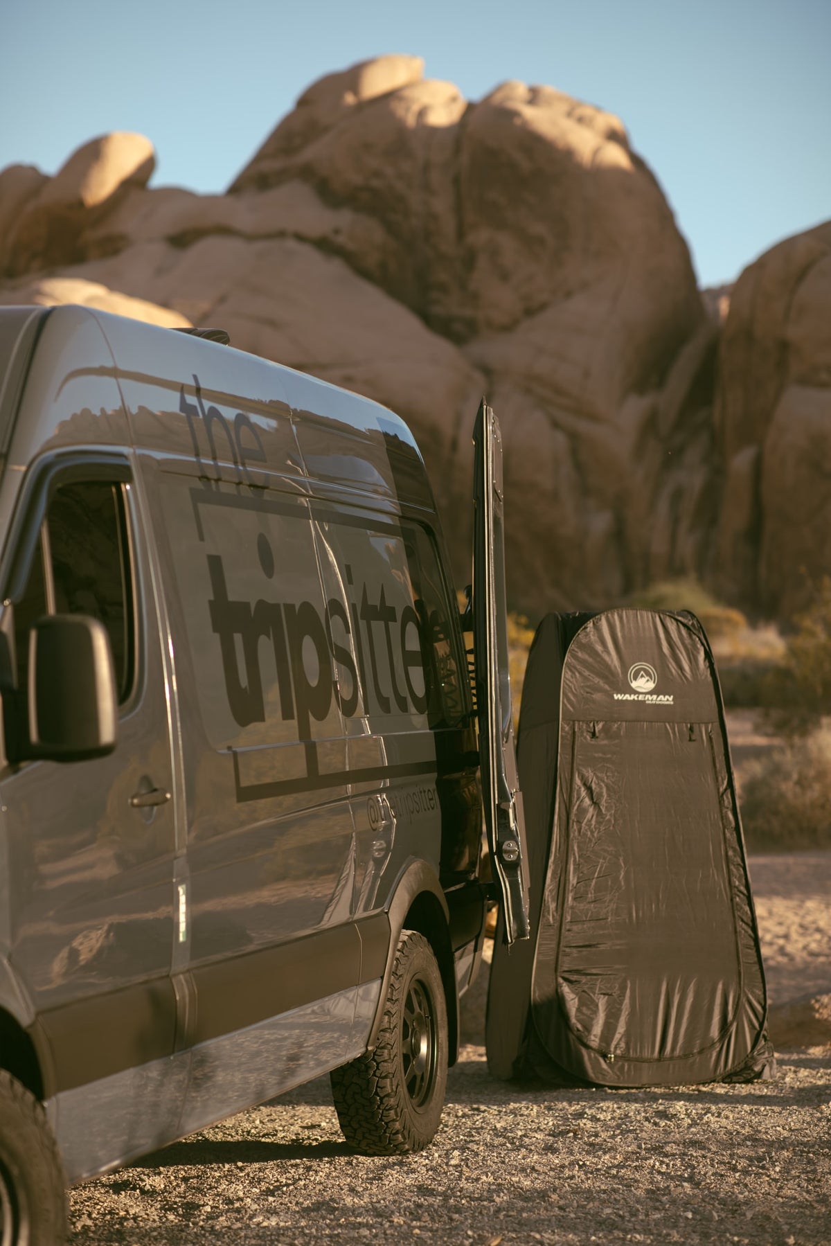 framing a beautiful Joshua Tree desert landscape of rocks & bushes.|RV rental amenities: a stainless steel trash can — photo 19