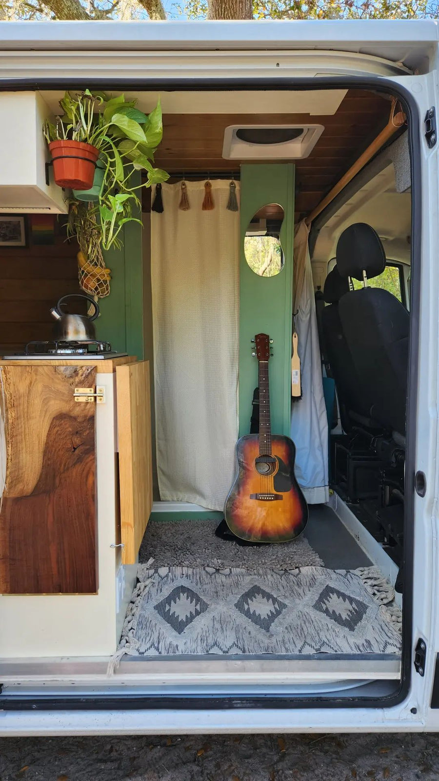 pull-out table for coffee & chess. Perfect for van life adventures.|Cozy rv rental interior: person relaxing on a bench