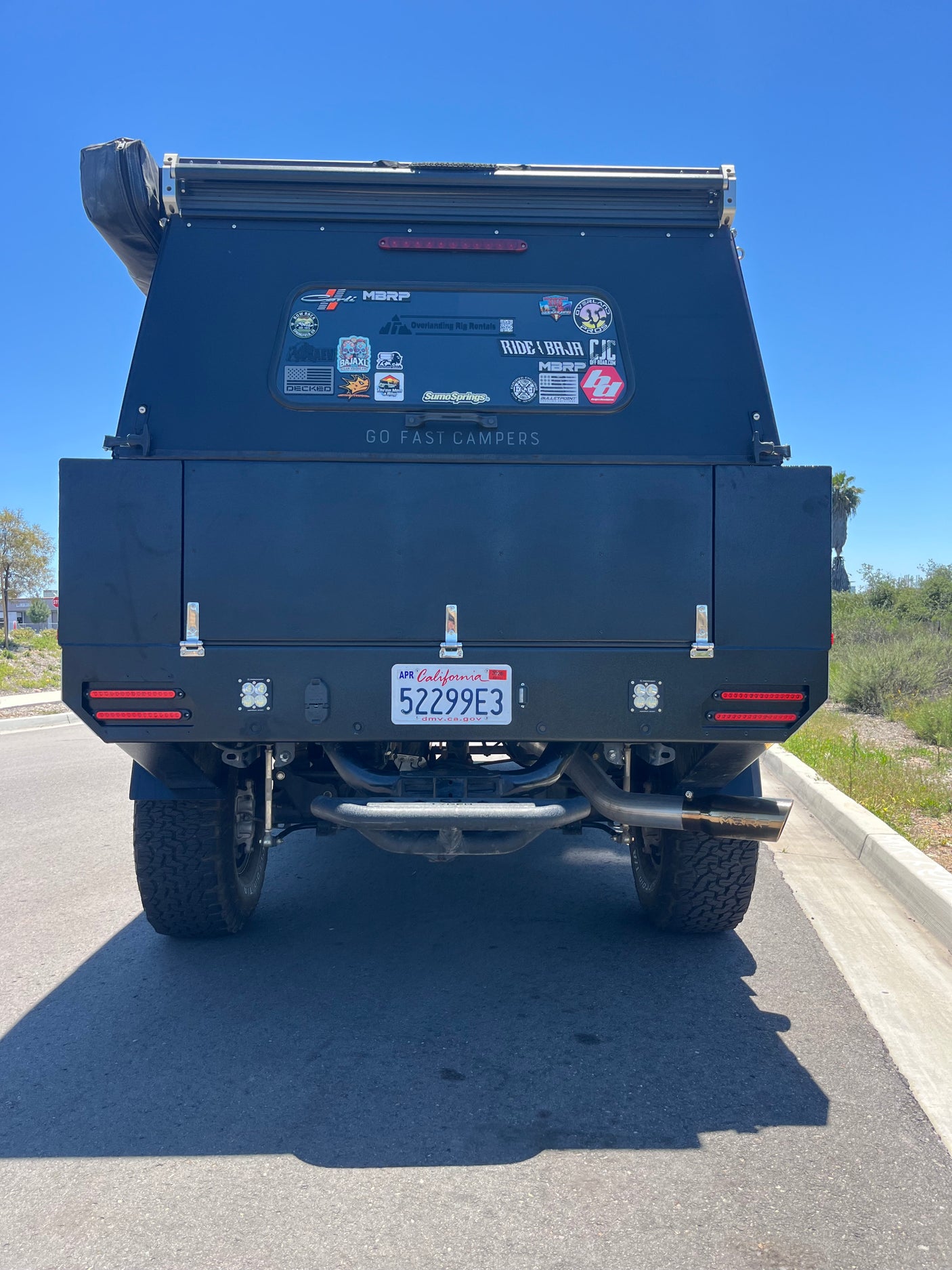 Back of a black "Go Fast Campers" overlanding rig, featuring custom lights. An ideal rv rental for your next outdoor adventure.