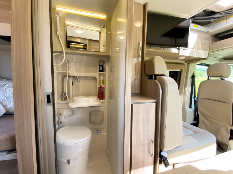 and large windows. Your comfortable road trip adventure awaits.|Modern rv rental interior: light kitchen