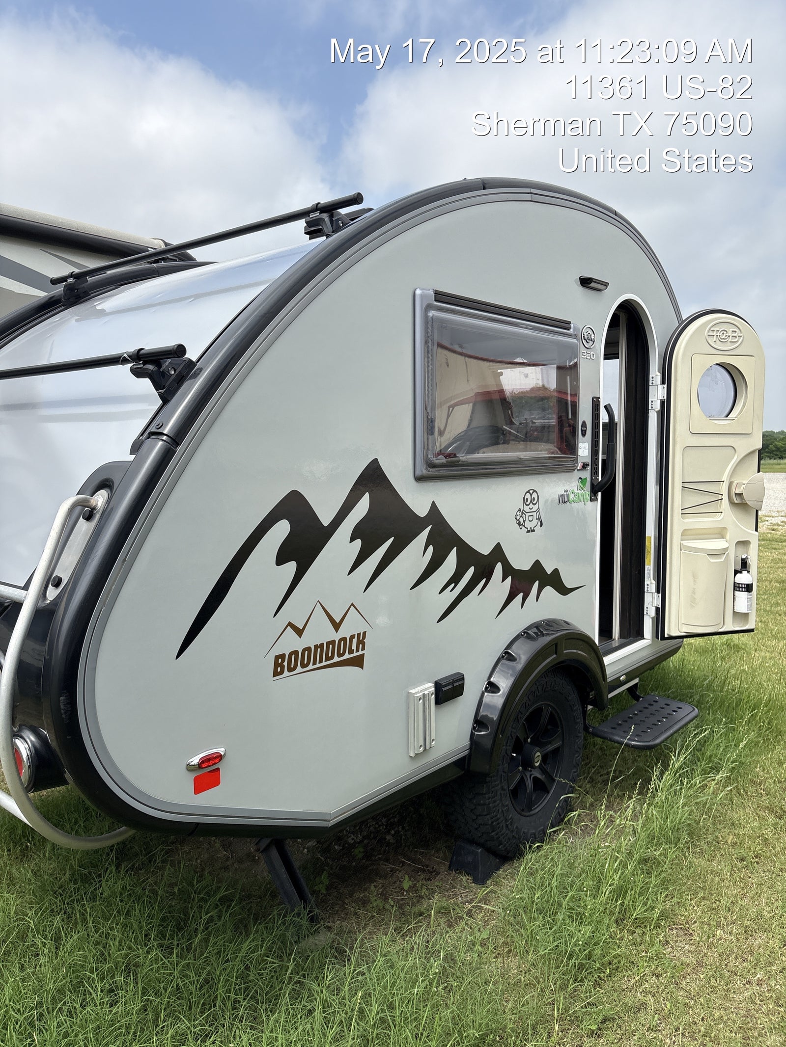 This nuCamp T@B 320 Boondock teardrop rv rental, a compact camper, is ready for adventure, parked on grass.