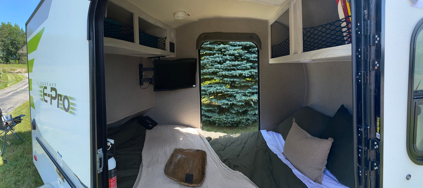 Cozy Flagstaff E-Pro RV rental interior with bed, TV, and storage visible. Perfect for compact camper adventures.