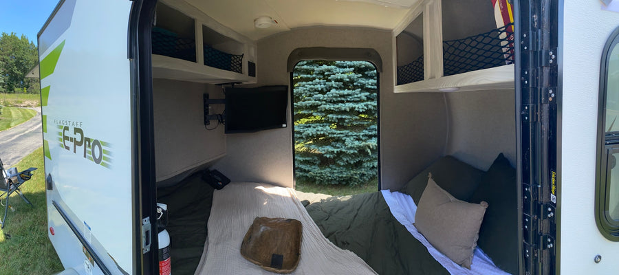 Cozy Flagstaff E-Pro RV rental interior with bed, TV, and storage visible. Perfect for compact camper adventures.