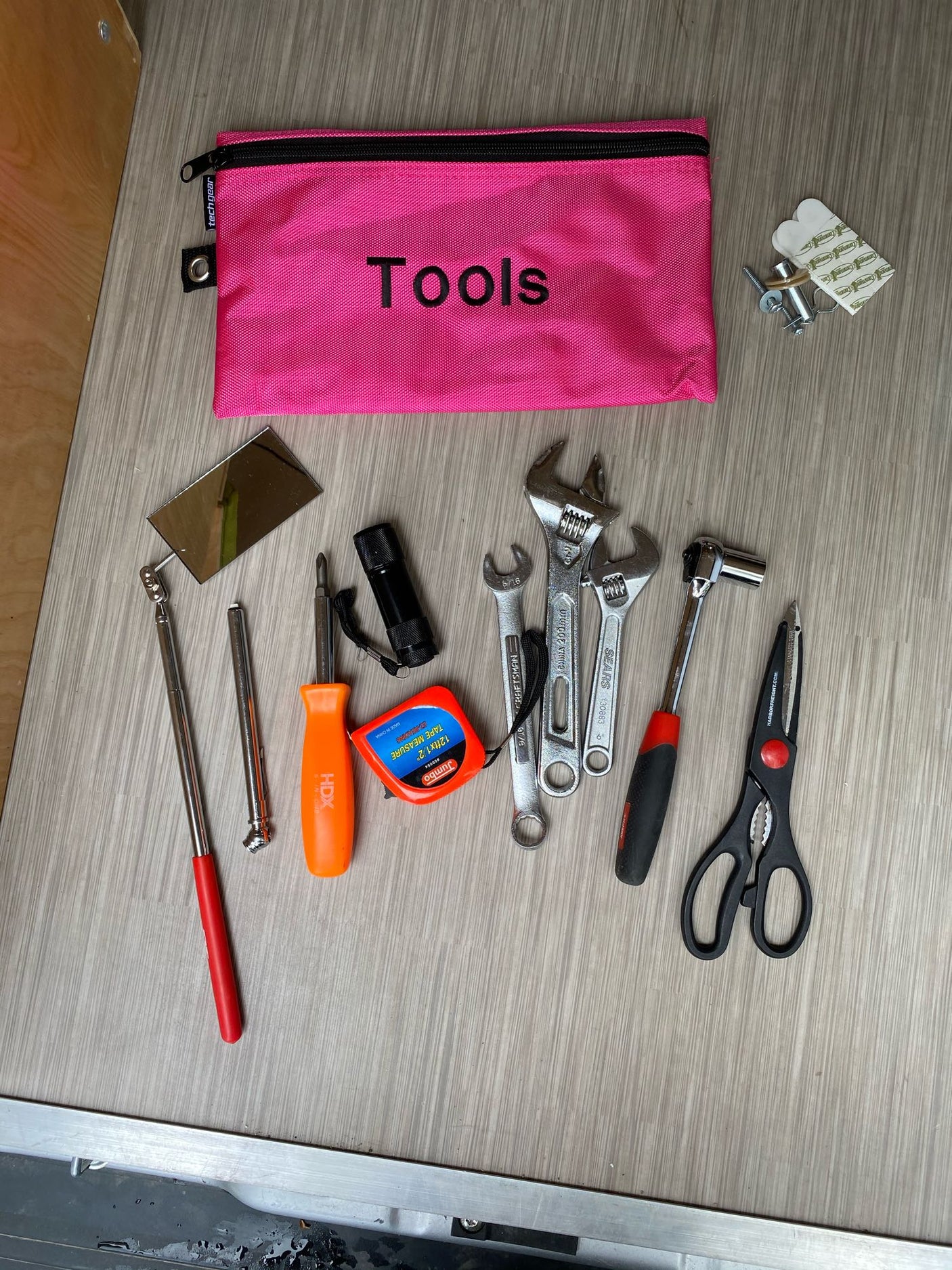 An RV rental essential: a pink "Tools" bag filled with wrenches, screwdriver, tape measure & more for quick fixes.