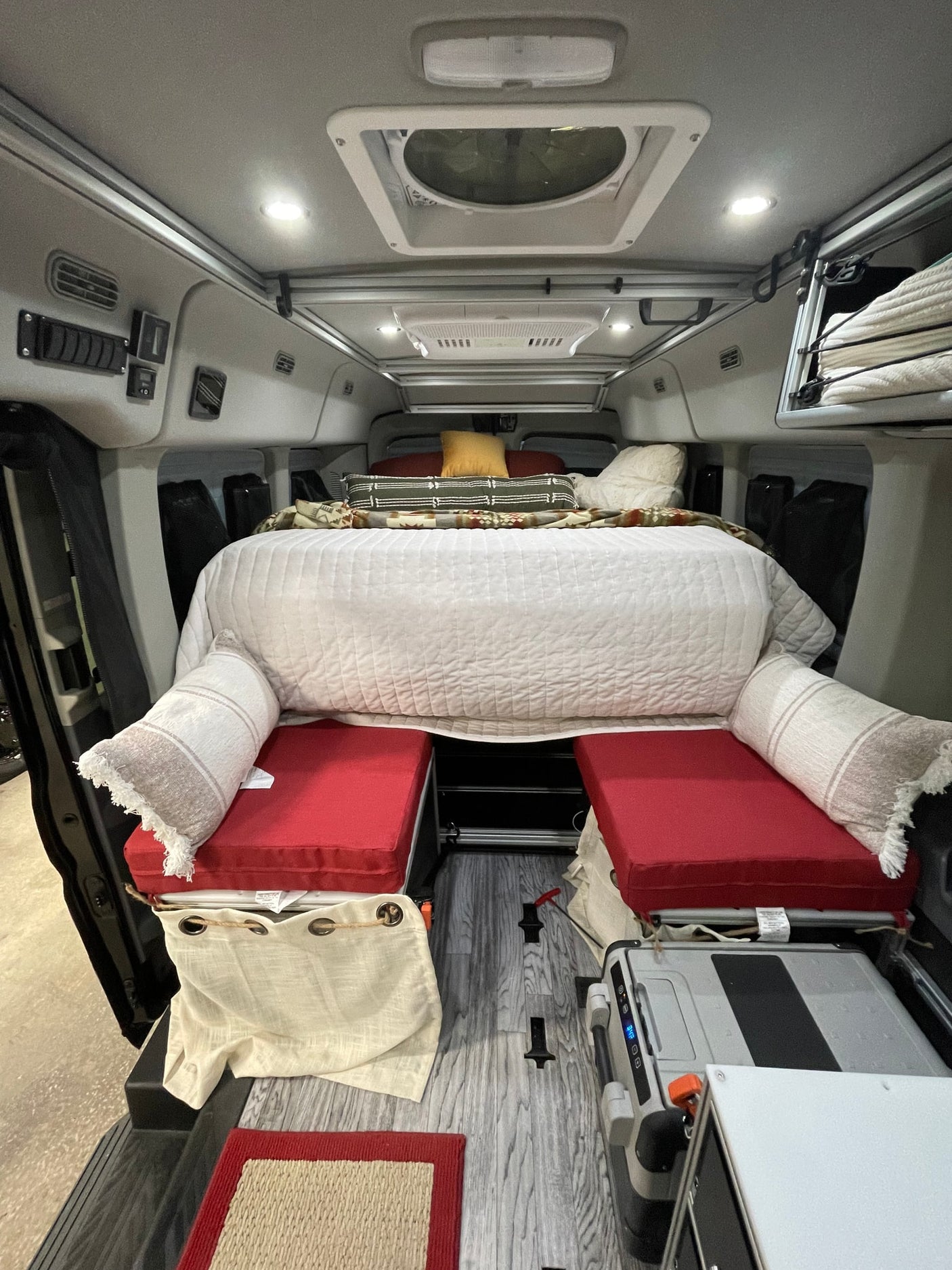 Inside this RV rental: a plush bed, modular seating, and a portable fridge make for comfortable van life.