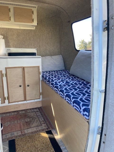 and tall trees surround the peaceful setup.|Cozy RV rental interior: kitchen sink