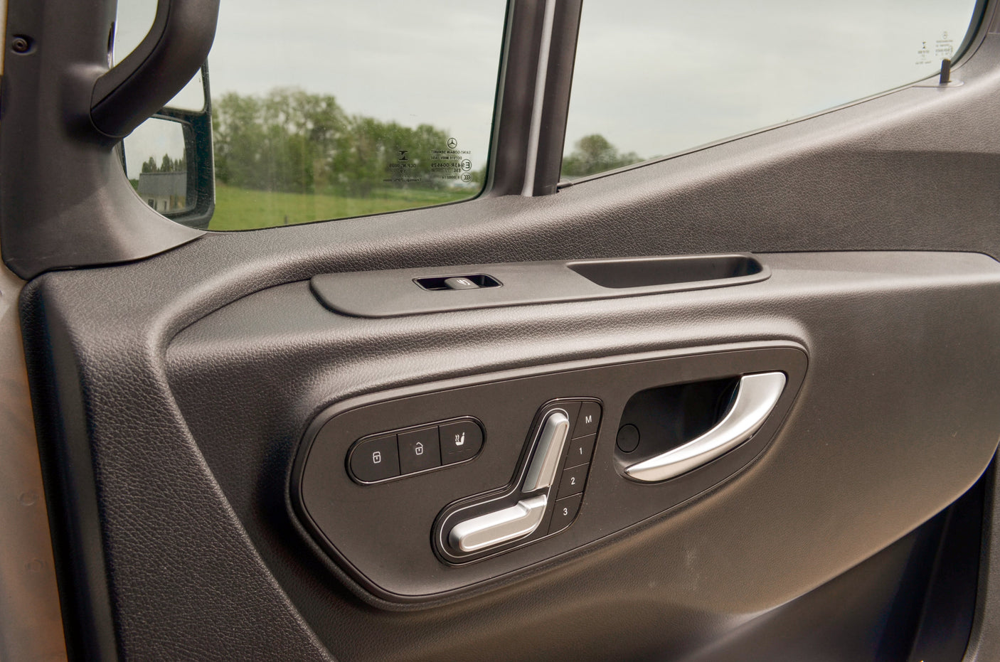RV rental vehicle's driver's door panel featuring power seat controls with memory, door locks, and window switch.